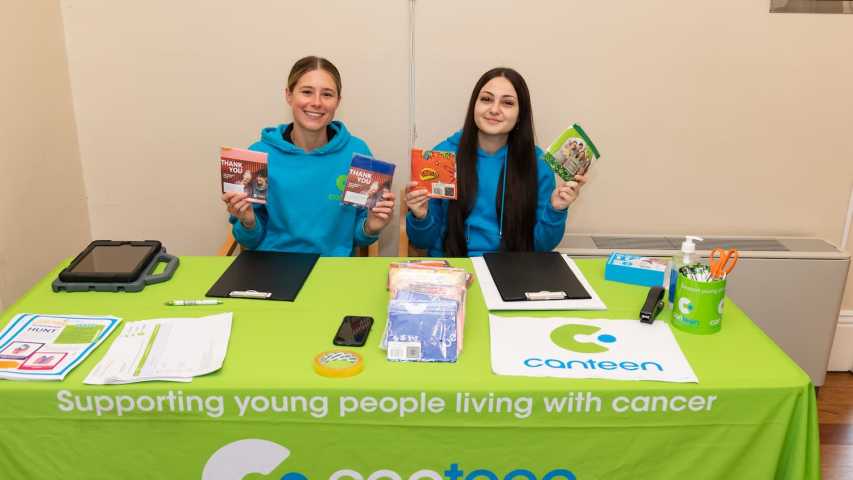 Canteen volunteers at the Canteen table handing out bandannas and Luna Park tickets