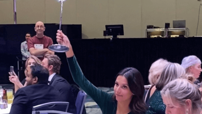 Vitoria Maranda from Neith Capital is holding up a paddle at the gala fundraiser event