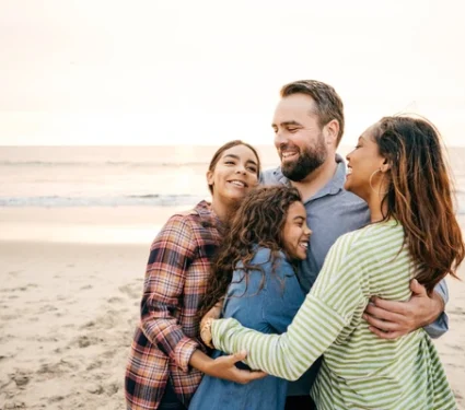 A happy and relieved family hugging together after receiving cancer support